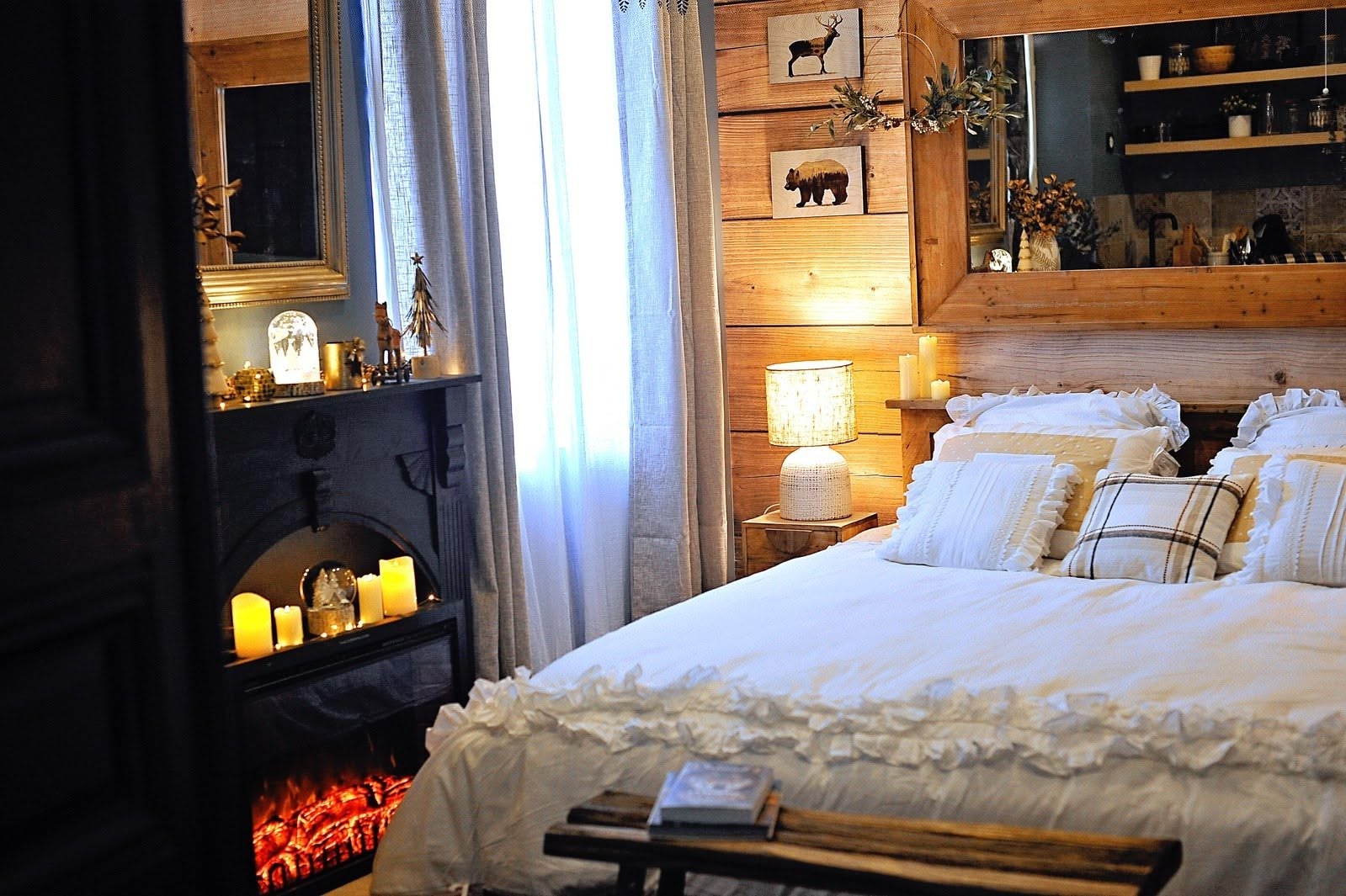 Love room chalet de montagne avec lit king size en bois, jacuzzi, cheminée électrique, coussins en fourrure, bougies, décoration chaleureuse, réservation Airbnb et Booking.
