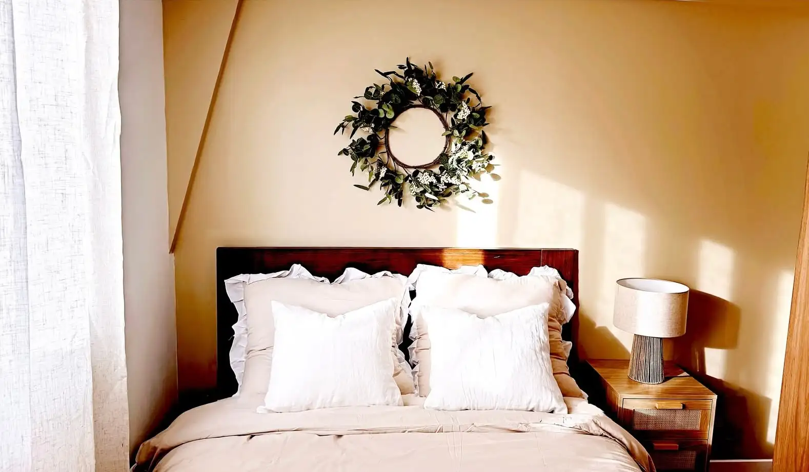 Chambre rénovée en colocation avec un lit en bois, une décoration soigneuse aux tons chauds, une ambiance cosy et apaisante.