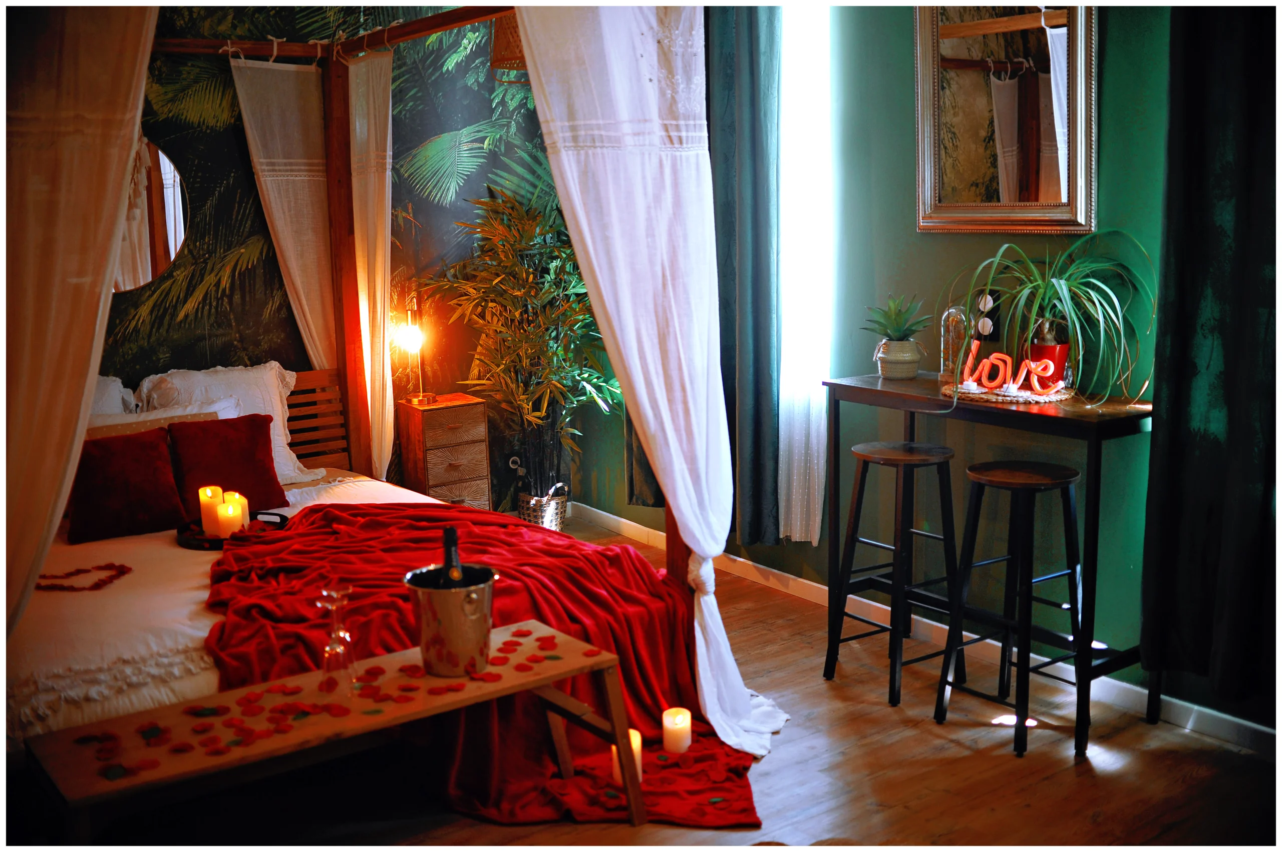 Love room romantique à thème jungle à Evreux avec lit king size, lit à baldaquin, papier peint exotique, écran géant, jacuzzi, plantes, décoration sur-mesure, réservation Airbnb et Booking.