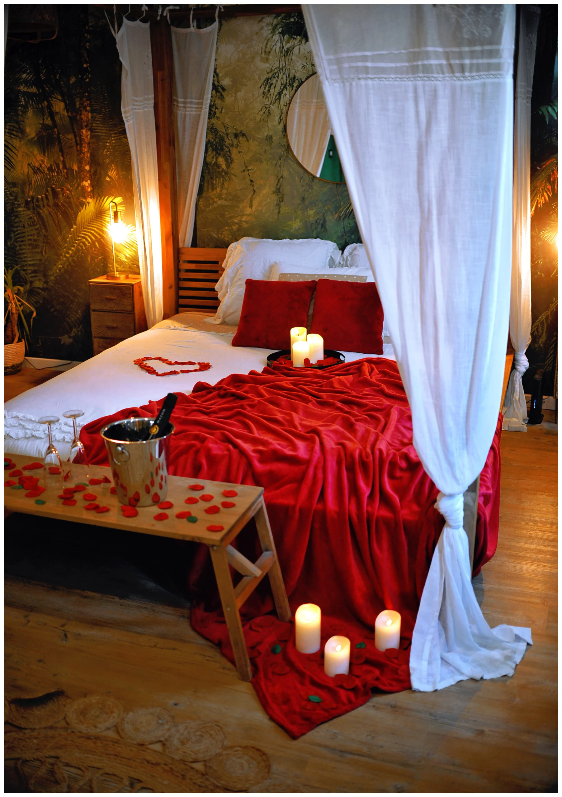 Love room romantique à thème jungle avec lit king size, lit à baldaquin, papier peint exotique, écran géant, jacuzzi, plantes, décoration sur-mesure, réservation Airbnb et Booking.