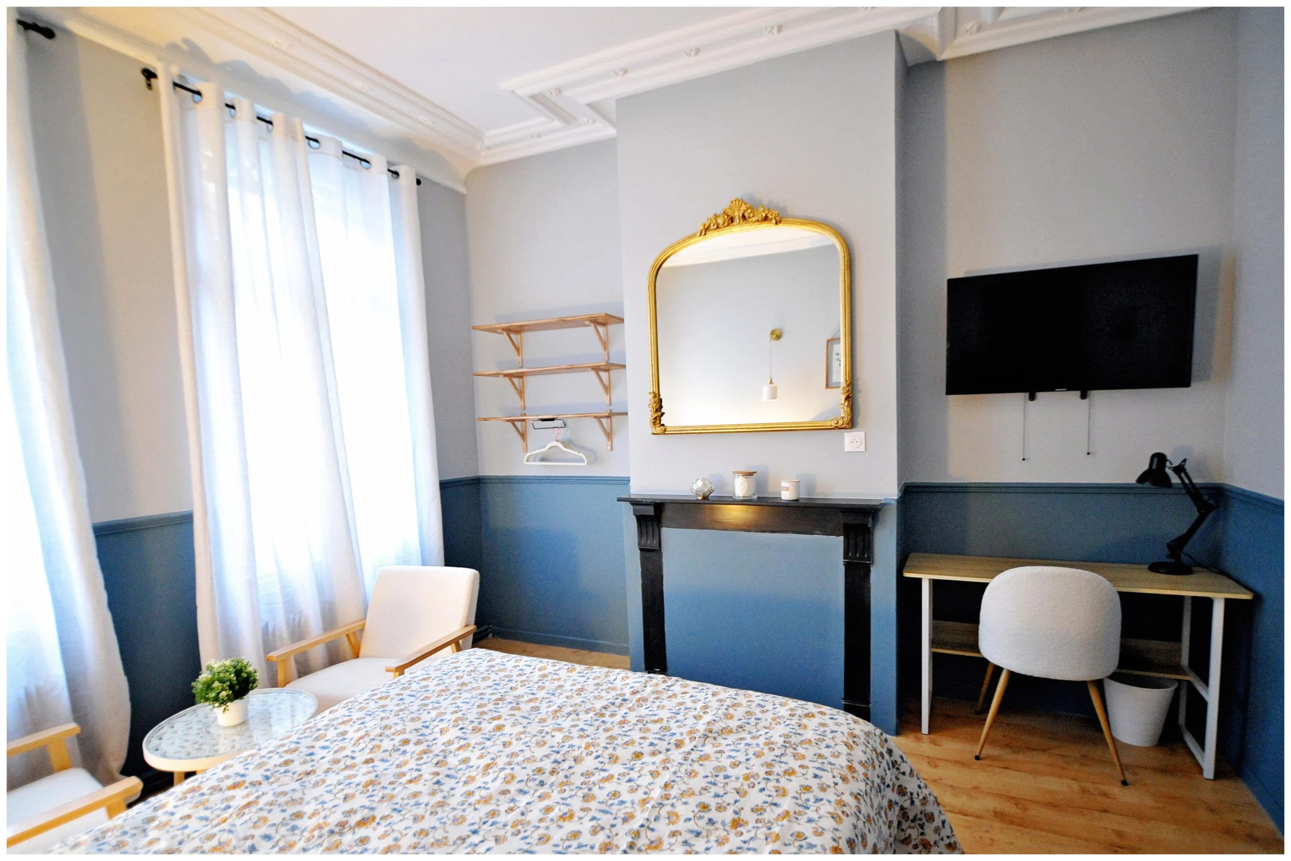 Chambre rénovée en colocation avec un lit coffre pratique, une décoration chaleureuse aux tons bleu et gris, une tête de lit en osier et une ambiance cosy et apaisante.